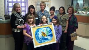 Jenna, Peyton and Kendal posing with The Painting of Hope (created by artist Ronald Fenty) and the staff of the Hunterdon Regional Cancer Center in Flemington, NJ. 